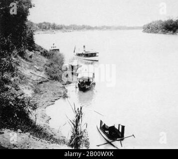 Thailand: Barges and a steamboat on the Siamese side of the Mekong River between Mukdahan and Nong Khai in 1902.  The River Mekong is the world's 12th-longest river. From its Himalayan source on the Tibetan plateau, it flows some 4,350 km (2,703 miles) through China's Yunnan province, Burma, Laos, Thailand, Cambodia and Vietnam, finally draining in the South China Sea.  The recent construction of hydroelectric dams on the river and its tributaries has reduced the water flow dramatically during the dry season in Southeast Asia. Stock Photo