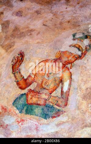 Sri Lanka: Sigiriya's 'Cloud Maidens' adorn the rock face high up over the surrounding countryside.  Sigiriya (Lion's rock) is an ancient rock fortress and palace ruin situated in the central Matale District of Sri Lanka, surrounded by the remains of an extensive network of gardens, reservoirs, and other structures. Sigiriya was built during the reign of King Kasyapa I (CE 477 – 495) and after his death it was used as a Buddhist monastery until the 14th century. Stock Photo