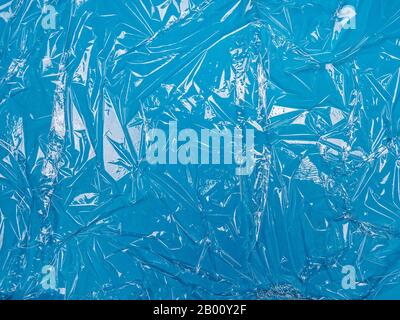 Transparent plastic foil on blue background Stock Photo