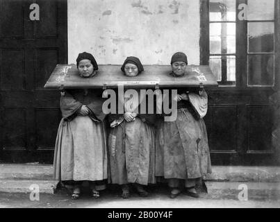 China: Three women wearing a cangue or form of portable stocks as a punishment, c. 1900.  A cangue was a device that was used for public humiliation and corporal punishment in China and some other parts of East Asia and Southeast Asia until the early years of the 20th century. It was somewhat similar to the pillory used for punishment in the West, except that the board of the cangue was not fixed to a base, and had to be carried around by the prisoner. Stock Photo