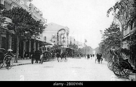 Vietnam: Looking toward Hang Khay Street from Trang Tien Street, Hanoi (early 20th century).  The Old Quarter, near Hoan Kiem Lake, consisted of only about 36 streets at the beginning of the 20th century. Each street then had merchants and households specializing in a particular trade, such as silk, jewellery, silversmiths, etc. Most street names in Hanoi's Old Quarter begin 'Hang', meaning 'shop' or 'merchant'. The names still stand to this day. 'Hang Khay' means 'Trays Street' though the majority of merchants sold furniture such as cabinets, chairs and  wardrobes. Stock Photo