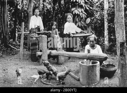 Thailand: Husking rice in Northern Thailand, early 20th Century.  The history of Northern Thailand is dominated by the Lanna Kingdom, which was founded in 1259 by King Mangrai and remained an independent force until the 16th century.  Much of Northern Thailand is mountainous. Stock Photo