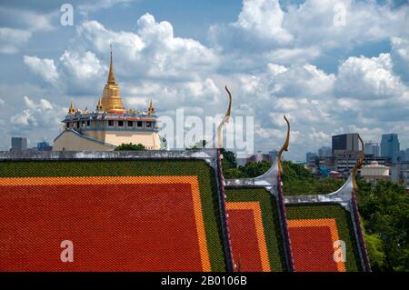 Thailand: Wat Ratchanadda and the Golden Mount in the background from the Loha Prasad, Bangkok.  Wat Saket Ratcha Wora Maha Wihan (usually Wat Saket) dates back to the Ayutthaya era, when it was called Wat Sakae. King Rama I (1736 - 1809) or Buddha Yodfa Chulaloke renovated the temple and renamed it Wat Saket. The Golden Mount (Phu Khao Thong) is a steep hill inside the Wat Saket compound. It is not a natural outcrop, but an artificial hill built during the reign of Rama III (1787 - 1851) or King Jessadabodindra. Stock Photo