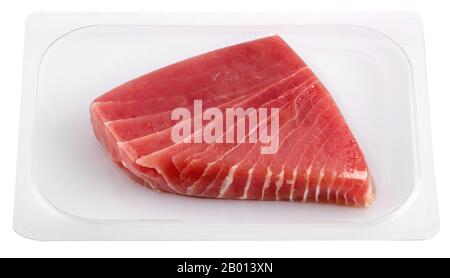 Vacuum packed tuna fillet piece in transparent plastic viewed in close-up isolated on white background. Food packaging for preserving the freshness an Stock Photo