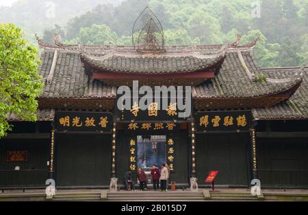 China: Entrance to Baoguo Si (Declare Nation Temple), at the foot of Emeishan (Mount Emei), Sichuan Province.  Baoguo Si (Declare Nation Temple), at the foot of Mount Emei, was first constructed in the 16th century during the Ming Dynasty (1368-1644).  At 3,099 metres (10,167 ft), Mt. Emei is the highest of the Four Sacred Buddhist Mountains of China. The patron bodhisattva of Emei is Samantabhadra, known in Chinese as Puxian. 16th and 17th century sources allude to the practice of martial arts in the monasteries of Mount Emei. Stock Photo