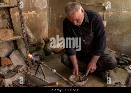 Damghan, Iran - May 25, 2019: Portait of Iranian worker in his littele blacksmith shop, Damghan, Iran. Stock Photo