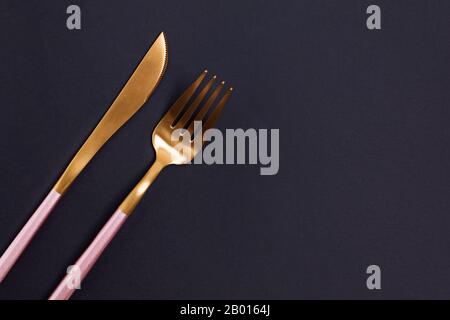 Elegant golden cutlery on black background Stock Photo