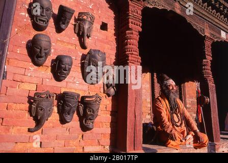 Nepal: Sadhu (Holy Man) in Durbar Square, Kathmandu.  They are known, variously, as sadhus (saints, or 'good ones'), yogis (ascetic practitioners), fakirs (ascetic seeker after the Truth) and sannyasins (wandering mendicants and ascetics). They are the ascetic – and often eccentric – practitioners of an austere form of Hinduism. Sworn to cast off earthly desires, some choose to live as anchorites in the wilderness. Others are of a less retiring disposition, especially in the towns and temples of Nepal's Kathmandu Valley. Stock Photo