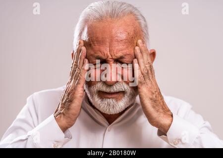 Portrait of senior man who is having headache. Stock Photo