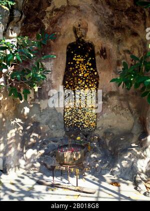 Thailand: A grotto containing a shadow of the Buddha, Wat Chakrawat, Bangkok.  Wat Chakkrawat is famous for its live crocodiles and also a small grotto containing what is called a Buddha shadow. Visitors press gold leaf on the shadow shape. Stock Photo