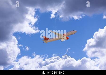 An airline plane flying in a blue sky inside big white clouds. Image with copy space. Stock Photo