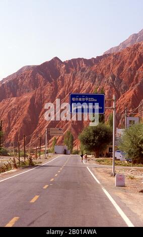 China: The red mountains of the Ghez River (Ghez Darya) canyon, Karakoram Highway.  The Zhongba Gonglu or Karakoram Highway is an engineering marvel that was opened in 1986 and remains the highest paved road in the world. It connects China and Pakistan across the Karakoram mountain range, through the Khunjerab Pass, at an altitude of 4,693 m/15,397 ft. Stock Photo