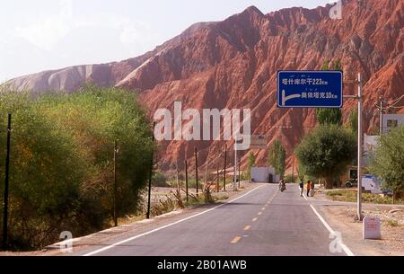 China: The red mountains of the Ghez River (Ghez Darya) canyon, Karakoram Highway.  The Zhongba Gonglu or Karakoram Highway is an engineering marvel that was opened in 1986 and remains the highest paved road in the world. It connects China and Pakistan across the Karakoram mountain range, through the Khunjerab Pass, at an altitude of 4,693 m/15,397 ft. Stock Photo