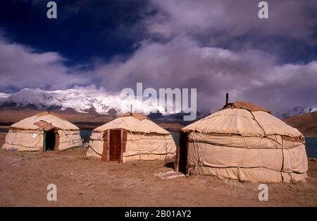 China: Kirghiz yurts at Lake Karakul on the Karakoram Highway, Xinjiang.  Two small settlements of Kirghiz (Kyrgyz or Kirgiz) nomads lie by the side of Lake Karakul high up in the Pamir Mountains. Visitors can stay overnight in one of their mobile homes or yurts – Kirghiz men will approach travellers as they arrive at the lake and offer to arrange this accommodation. The Kyrgyz form one of the 56 ethnic groups officially recognized by the People's Republic of China. There are more than 145,000 Kyrgyz in China.  The Zhongba Gonglu or Karakoram Highway is an engineering marvel.