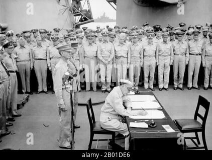 USA/Japan: General Douglas MacArthur signs the Japanese Instrument of Surrender, USS Missouri, Tokyo Bay, September 2, 1945.  General Douglas MacArthur signs as Supreme Allied Commander during formal surrender ceremonies on the USS Missouri in Tokyo Bay. Behind General MacArthur are Lieutenant General Jonathan Wainwright and Lieutenant General A. E. Percival.  On August 28, the occupation of Japan began. The surrender ceremony was held on September 2 aboard the USS Missouri, at which officials from the Japanese government signed the Japanese Instrument of Surrender, ending World War II. Stock Photo