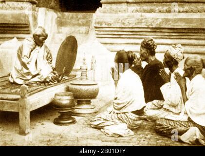 Burma: A Buddhist abbot (Burmese: 'sayadaw') recites precepts to devotees, c. 1892-1896.  Buddhist monks collect alms - food prepared by devotees and laypersons who make merit by donating it - every morning in Burma and most Theravada Buddhist countries. This is their only food for the day. Monks do not eat after 12 noon.  Legend attributes the first Buddhist doctrine in Burma to 228 BC when Sonna and Uttara, two ambassadors of the Emperor Ashoka the Great of India, came to the country with sacred texts. However, the golden era of Buddhism truly began in the 11th century. Stock Photo