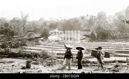 Burma: Shan farmers with village in the background, c. 1892-1896.  Located in the northeast of the country, Shan State covers one-quarter of Burma’s land mass. It was traditionally separated into principalities and is mostly comprised of ethnic Shan, Burman Pa-O, Intha, Taungyo, Danu, Palaung and Kachin peoples. Stock Photo