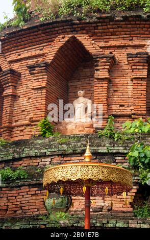 Thailand: Detail of the circular Chedi Sri Phuak at Wat Phuak Hong, Chiang Mai.  Wat Phuak Hong (วัดพวกหงษ์), the 'Temple of the Flight of Swans', is located in the southwest corner of Chiang Mai Old City. A typical small Lan Na temple, it is chiefly notable for the round stupa that stands to the west of the viharn. Built in the 16th century, the rounded structure has seven diminishing tiers encircled by a total of 52 niches for images of the Buddha,some of which survive today, though in a rather damaged condition. Stock Photo
