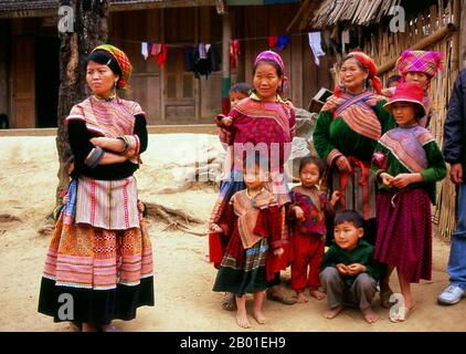 Vietnam: Women and children in a Flower Hmong village near Phong Nien, Lao Cai Province.  The hills around Bac Ha are home to ten separate minorities, including Dao, Giay, Nung and Tai, but the most distinctive and colourful are the Flower (Flowery) Hmong. From before dawn they converge on Bac Ha’s dusty town centre and, especially, the concrete market. Goods sold and exchanged include fruit and vegetables of every description, fresh meat and wild orchids.  The Hmong are an Asian ethnic group from the mountainous regions of China, Vietnam, Laos, and Thailand. Stock Photo