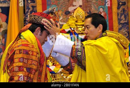 Bhutan: His Majesty Ugyen Wangchuck, 4th Druk Gyalpo or 'Dragon King' (r. 1972-2006), crowning his son Jigme Khesar Namgyel Wangchuck, 5th Druk Gyalpo, in 2008. Photo handout by the Royal Government of Bhutan (CC BY-SA 3.0 License).  The Druk Gyalpo ('Dragon King') is the head of state of Bhutan. He is also known in English as the King of Bhutan. Bhutan, in the local Dzongkha language, is known as Dryukyul which translates as 'The Land of Dragons'. Thus, while Kings of Bhutan are known as Druk Gyalpo ('Dragon King'), the Bhutanese people call themselves the Drukpa, meaning 'Dragon people'. Stock Photo