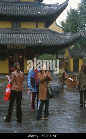 China: Worshippers at the Longhua Temple, Shanghai.  Longhua Si and Longhua Ta (Longhua Temple and Pagoda) is Shanghai’s largest Buddhist temple and is the finest ancient monument in the city. It dates from 247 CE and was built by the Emperor Sun Quan in honour of his mother. It has since been destroyed and rebuilt several times. The temple site consists of seven halls that are all used for religious purposes. The 60-m (197-ft), seven-storey tower was rebuilt in 977. Stock Photo