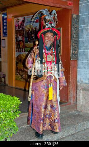 China: A Naxi dongba (shaman), Lijiang Old Town, Yunnan Province.  The Naxi or Nakhi are an ethnic group inhabiting the foothills of the Himalayas in the northwestern part of Yunnan Province, as well as the southwestern part of Sichuan Province in China. The Naxi are thought to have come originally from Tibet and, until recently, maintained overland trading links with Lhasa and India.  The Naxi form one of the 56 ethnic groups officially recognised by the People's Republic of China. The Naxi are traditionally followers of the Dongba religion. Stock Photo