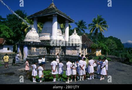 Sri Lanka: Schoolchildren next to the covered stupa at Gadaladeniya Temple, Kandy.  The Gadaladeniya Temple is a Buddhist temple dating from 1344 and is believed to have been built by King Buwanekabahu IV (r. 1344 - 1354).  Kandy is Sri Lanka's second biggest city with a population of around 170,000 and is the cultural centre of the whole island. For about two centuries (until 1815) it was the capital of Sri Lanka. Stock Photo