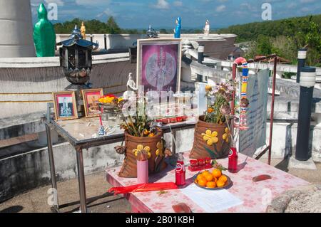 Thailand: Shrine in front of the Goddess Kuan Yin statue overlooking the town above Wat Matchimaphum, Trang Town, Trang Province, southern Thailand.  Trang has been a trading centre since at least the 1st century CE. It grew to prosperity between the 7th and 13th centuries during the Srivijaya period and remains an important commercial town today.  Rubber, palm oil and fishing are the mainstays of the town's economy. Tourism is making an increasing impact as Trang’s Andaman Coast and islands are increasingly developed and popularised. Stock Photo