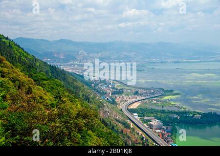 China: Highway leading to Kunming seen from Long Men (Dragon Gate), Xishan (Western Hills), near Kunming, Yunnan Province.  Western Hills Forest Reserve lies in the Biji Mountain chain to the west of Kunming, China. It is visible from the eastern or northern banks of Dianchi Lake. Stock Photo