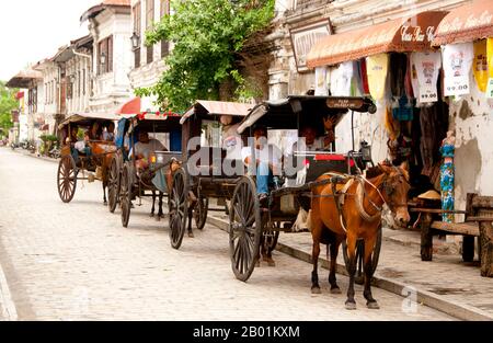 Philippines: Kalesa (horse-drawn carriage) lined up in the Mestizo District, Vigan, Ilocos Sur Province, Luzon Island.  The City of Vigan is the capital of the Province of Ilocos Sur and located on the western coast of the island of Luzon.  Vigan is the only surviving historic city in the Philippines that dates back to the 15th century Spanish colonial period. The town was also an important trading post in pre-colonial times with a community of Chinese traders from Fujian settled in the area.  Today it has been awarded UNESCO World Heritage Site status. Stock Photo