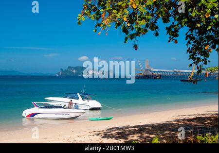 Thailand: Speedboats and the pier for the gypsum mine at the northern end of Hat Khlong Muang, Krabi Coast.  Hat Khlong Muang sits to the west of Hat Noppharat Thara and is shielded from Ao Nang by a long, rocky headland. The beach faces due west across the Andaman Sea towards Ko Phi Phi.  Krabi Province is made up of more than 5,000 sq km of jungle-covered hills and sharp, jagged karst outcrops, as well as more than 100km of luxuriant, pristine coastline and around 200 islands in the neighbouring Andaman Sea. Stock Photo