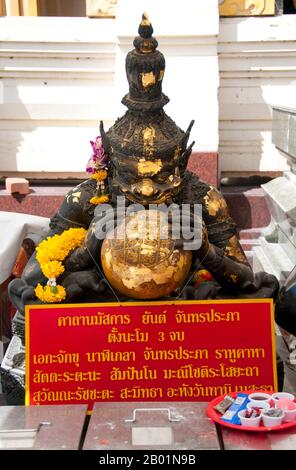 Thailand: A representation of Rahu (Snake Demon and causer of solar and lunar eclipses), swallowing the moon, Wat Traimit, Bangkok. In Hindu mythology, Rahu is a snake that swallows the sun or the moon causing eclipses. He is depicted in art as a dragon with no body riding a chariot drawn by eight black horses. Rahu is one of the navagrahas (nine planets) in Vedic astrology. The Rahu kala (time of day under the influence of Rahu) is considered inauspicious. Wat Traimit, a Thai Buddhist temple in Chinatown, Bangkok, is chiefly known for housing the world's largest solid gold Buddha figure. Stock Photo