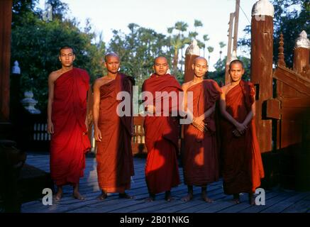 Burma/Myanmar: A group of monks at sunset, Shwe In Bin Kyaung, Mandalay.  Mandalay, a sprawling city of more than 1 million people, was founded in 1857 by King Mindon to coincide with an ancient Buddhist prophecy. It was believed that Gautama Buddha visited the sacred mount of Mandalay Hill with his disciple Ananda, and proclaimed that on the 2,400th anniversary of his death, a metropolis of Buddhist teaching would be founded at the foot of the hill. Stock Photo