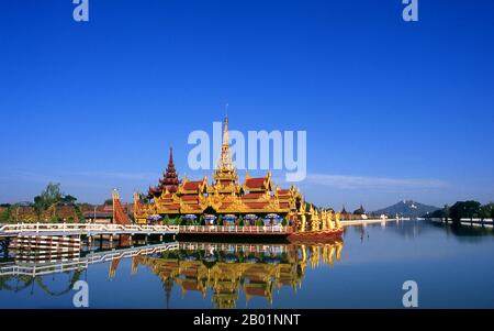 Burma/Myanmar: A replica of the Pyi Gyi Mon Royal Barge in the moat surrounding Mandalay Fort, Mandalay Hill in the background, Mandalay.  Mandalay, a sprawling city of more than 1 million people, was founded in 1857 by King Mindon to coincide with an ancient Buddhist prophecy. It was believed that Gautama Buddha visited the sacred mount of Mandalay Hill with his disciple Ananda, and proclaimed that on the 2,400th anniversary of his death, a metropolis of Buddhist teaching would be founded at the foot of the hill. Stock Photo
