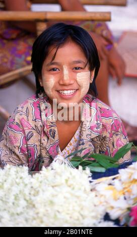 Burma/Myanmar: A young Bamar/Burman girl wearing the Burmese cosmetic thanaka, a yellow powder designed to protect the skin.  Thanaka (also spelt thanakha) is a yellowish-white cosmetic paste made from ground bark. It is a distinctive feature of Myanmar (formerly Burma) seen commonly applied to the face and sometimes the arms of women and girls and to a lesser extent men and boys. The use of thanaka has also spread to neighbouring countries including Thailand.  The earliest literary reference to thanaka is in a 14th century poem written by Mon-speaking King Razadarit's consort. Stock Photo