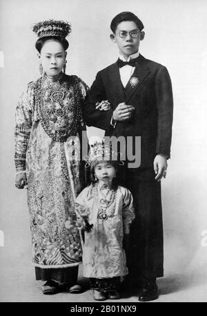 Malaysia/Singapore: A Peranakan bride and groom with tiny bridesmaid, Penang, early 20th century.  Peranakan Chinese and Baba-Nyonya are terms used for the descendants of late 15th and 16th-century Chinese immigrants to the Malay-Indonesian archipelago of Nusantara during the Colonial era.  Members of this community in Malaysia identify themselves as 'Nyonya-Baba' or 'Baba-Nyonya'. Nyonya is the term for the females and Baba for males. It applies especially to the ethnic Chinese populations of the British Straits Settlements of Malaya and the Dutch-controlled island of Java and other locations Stock Photo