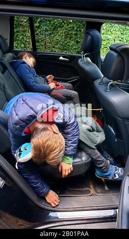 children fell asleep on a rear bench seat of a car, Germany Stock Photo