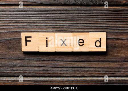 fixed word written on wood block. fixed text on table, concept. Stock Photo