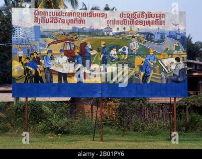 Laos: Construction and industry in Laos. Revolutionary Socialist realist-style political poster on the streets of Vientiane.  Socialist realism is a style of realistic art which was developed in the Soviet Union and became a dominant style in other communist countries. Socialist realism is a teleologically-oriented style having its purpose the furtherance of the goals of socialism and communism. Although related, it should not be confused with social realism, a type of art that realistically depicts subjects of social concern. Stock Photo