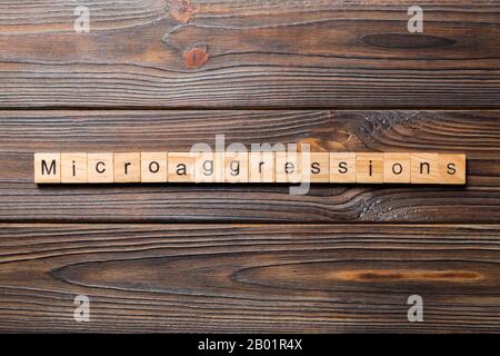Microaggressions word written on wood block. Microaggressions text on wooden table for your desing, concept. Stock Photo