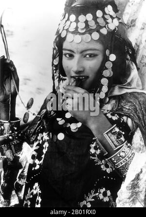 Algeria: Young Berber woman of the Ouled Nail tribe. Photograph by Rudolf Lehnert, 1904.  Berbers are the indigenous peoples of North Africa west of the Nile Valley. They are discontinuously distributed from the Atlantic to the Siwa Oasis, in Egypt, and from the Mediterranean to the Niger River. Historically they spoke various Berber languages, which together form a branch of the Afro-Asiatic language family.  Rudolf Franz Lehnert (Czech) and Ernst Heinrich Landrock (German) had a photographic company based in Tunis, Cairo and Leipzig before World War II. Stock Photo