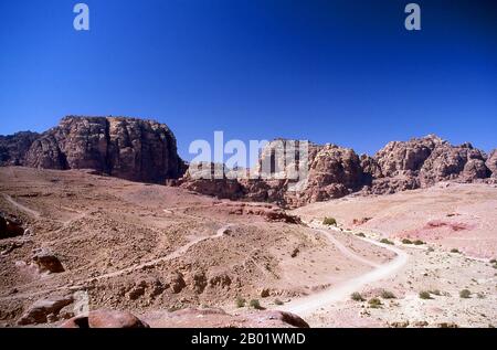 Jordan: Looking towards the Temple of Dushares (Qasr al-Bint), Petra.  Petra was first established as a city by the Nabataean Arabs in the 4th century BCE, and owed its birth and prosperity to the fact that it was the only place with clear and abundant water between the Hijaz trading centres of Mecca and Medina, and Palestine.  Hewn directly into the Nubian sandstone ridges of the south Jordanian desert, it seems probable that - given its excellent defensive position and good water supplies - Petra has been continually occupied from as early as Paleolithic times. Stock Photo