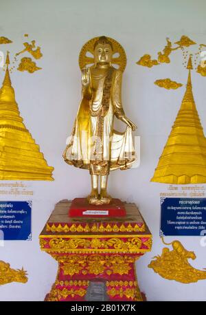 Thailand: Buddha in Abhaya Mudra in the cloister surrounding the old chedi at Wat Yang Kuang, Suriyawong Road, Chiang Mai, northern Thailand.  Wat Yang Kuang, Suriyawong Road, Chiang Mai has a long and chequered history. Originally mentioned in the Nirat Haripunchai (1517) as Wat Nang Rua, it was abandoned as a result of the destructive 18th century wars with Burma, leading to the abandonment of the city of Chiang Mai between 1775 and 1797 on the instruction of Chao Kawila. Stock Photo