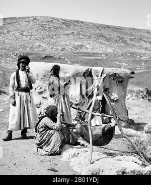 Palestine: Churning butter in Galilee, c. 1914.  Palestine is a name given to the geographic region between the Mediterranean Sea and the Jordan River. The region is also known as the Land of Israel, the Holy Land and the Southern Levant.  In 1832 Palestine was conquered by Muhammad Ali's Egypt, but in 1840 Britain intervened and returned control of the Levant to the Ottomans in return for further capitulations. The end of the 19th century saw the beginning of Zionist immigration and the Revival of the Hebrew language. Stock Photo