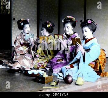 Japan: Four geisha reading from note books and studying the chanoyu Tea Ceremony, c. 1900.  The Japanese tea ceremony, also called the Way of Tea, is a Japanese cultural activity involving the ceremonial preparation and presentation of matcha, powdered green tea. In Japanese, it is called chanoyu or chadō, sadō. The manner in which it is performed, or the art of its performance, is called otemae. Zen Buddhism was a primary influence in the development of the tea ceremony.  Tea gatherings are classified as chakai or chaji. Stock Photo