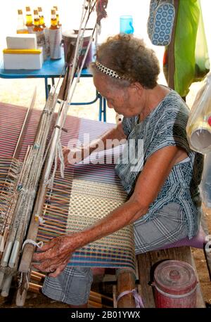 Thailand: Weavers in the Wiangyong district creating the famous Pha Mai Yok Dok silk fabrics, Lamphun, northern Thailand.  Pha Mai Yok Dok is an elaborately woven material in traditional method. Originally used in the northern royal court, it became popular during the reign of King Rama VI. The distinctive craftsmanship and skills in producing this type of silk have endeared it to those who prefer the traditional designs.  Lamphun was the capital of the small but culturally rich Mon Kingdom of Haripunchai from about 750 CE to the time of its conquest by King Mangrai (the founder of Chiang Mai) Stock Photo