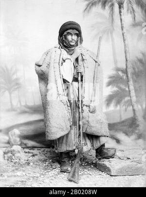 Arabia: 'A Bedouin Chief of Shepherds'. Photo by Félix Bonfils (1831-1885), c. 1880s.  Bedouin are a part of a predominantly desert-dwelling Arabian ethnic group traditionally divided into tribes, or clans, known in Arabic as ʿašāʾir. The term 'Bedouin' derives from a plural form of the Arabic word badawī, as it is pronounced in colloquial dialects. The Arabic term badawī derives from the word bādiyah, which means semiarid desert (as opposed to ṣaḥarāʾ which means desert).  Starting in the late nineteenth century, many Bedouin under British rule began to transit to a seminomadic life. Stock Photo