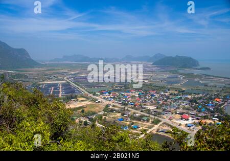 Thailand: View of Ban Khao Daeng and the surrounding countryside from the Khao Daeng viewpoint, Khao Sam Roi Yot National Park, Prachuap Khiri Khan Province.  Khao Sam Roi Yot became Thailand’s first coastal National Park in 1996. It covers an area of approximately 100 square kilometres (40 square miles) including steep limestone mountains riddled in places with caves, marshes, mangrove swamps, sandy beaches and shallow sea waters along the coast.  The name sam roi yot means ‘three hundred peaks’ and this refers directly to the many limestone outcrops and peaks that characterise the park. Stock Photo