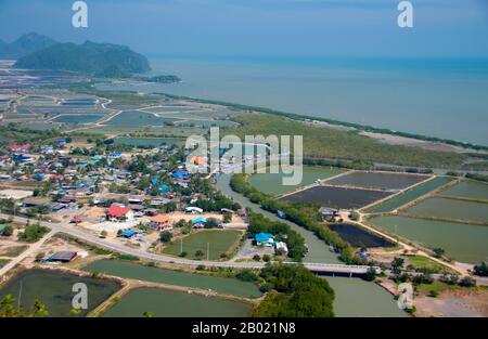 Thailand: View of Ban Khao Daeng and the surrounding countryside from the Khao Daeng viewpoint, Khao Sam Roi Yot National Park, Prachuap Khiri Khan Province.  Khao Sam Roi Yot became Thailand’s first coastal National Park in 1996. It covers an area of approximately 100 square kilometres (40 square miles) including steep limestone mountains riddled in places with caves, marshes, mangrove swamps, sandy beaches and shallow sea waters along the coast.  The name sam roi yot means ‘three hundred peaks’ and this refers directly to the many limestone outcrops and peaks that characterise the park. Stock Photo