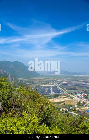 Thailand: View of Ban Khao Daeng and the surrounding countryside from the Khao Daeng viewpoint, Khao Sam Roi Yot National Park, Prachuap Khiri Khan Province.  Khao Sam Roi Yot became Thailand’s first coastal National Park in 1996. It covers an area of approximately 100 square kilometres (40 square miles) including steep limestone mountains riddled in places with caves, marshes, mangrove swamps, sandy beaches and shallow sea waters along the coast.  The name sam roi yot means ‘three hundred peaks’ and this refers directly to the many limestone outcrops and peaks that characterise the park. Stock Photo